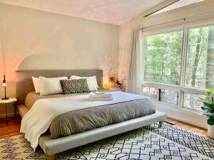 a bedroom with a large bed and a large window at Mid-Century Gem Creekside King Beds Near UNC in Chapel Hill