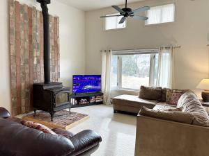 a living room with a couch and a stove at Charming, Spacious, Contemporary Mountain Retreat in Whitehall