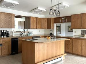 a kitchen with wooden cabinets and a large island in it at Charming, Spacious, Contemporary Mountain Retreat in Whitehall