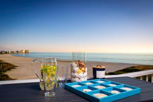 a table with a tray of food and drinks on the beach at Waterfront Condo Beach Access & Pool Luxury in Marco Island