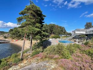 a house on the beach with a tree at Lägenhet i Strömstad in Strömstad