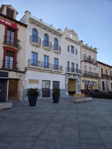 a large white building with balconies on a street at Luxury Apartament Plaza in Alcazar de San Juan
