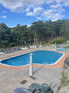 a large blue swimming pool with chairs and trees at Lägenhet i Strömstad in Strömstad +13 photos