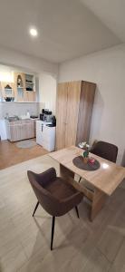 a living room with a wooden table and a kitchen at STUDIO Apartman in Gheorgheni +7 photos