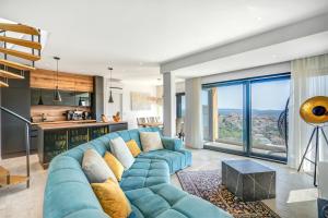 a living room with a blue couch and a kitchen at Villa Luca in Seget Vranjica