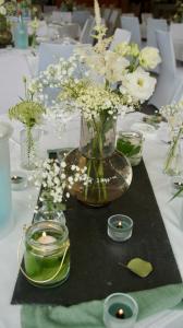 a table with a vase of flowers and candles on it at Hotel Drei Rosen in Borna