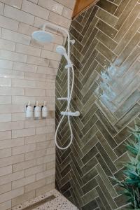 a shower in a bathroom with a brick wall at Maroska Pine in Kismaros +20 photos