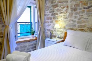 a bedroom with a bed and a stone wall at Apartments Festum in Šibenik