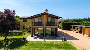 a house with a large glass door on a yard at Villa Luna Appartements und Spa in Calmasino