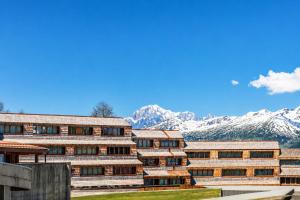 a building with snow covered mountains in the background at Petit Chalet Pila in Pila