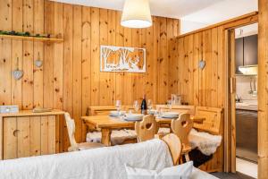 a dining room with a table and wooden walls at Petit Chalet Pila in Pila +37 photos