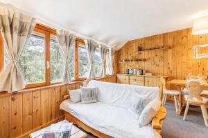 a living room with a couch and a table at Petit Chalet Pila in Pila