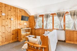 a living room with wood paneling and a chair and a tv at Petit Chalet Pila in Pila