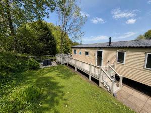 a mobile home with a deck next to a yard at The Bay Hideaway in Bucks Mills