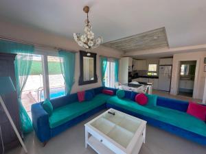a living room with a blue couch and a table at Evalacati-Villa Palma-Central villa with private pool and garden in Çeşme