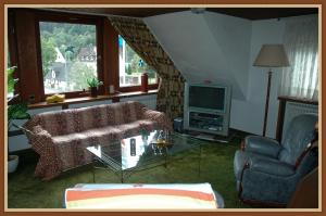 a living room with a couch and a tv at Panoramablick 85 m2 5 persoons in Lennestadt
