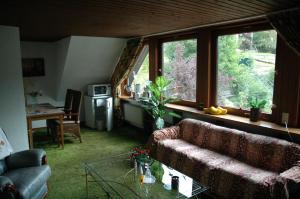 a living room with a couch and a table at Panoramablick 85 m2 5 persoons in Lennestadt