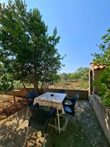 a wooden table and chairs in a yard at Rose Zaglav in Zaglav