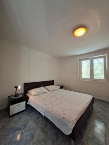 a bedroom with a bed and a lamp on a night stand at Rose Zaglav in Zaglav
