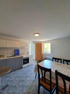 a kitchen and dining room with a table and chairs at Rose Zaglav in Zaglav +4 photos