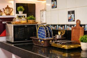 a kitchen with a counter with a stove and a microwave at C 44 the local history in Jaipur