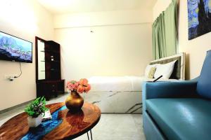 a living room with a vase with flowers on a table at Zenia IT Rooms in Pune