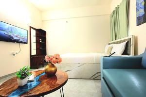 a living room with a table and a bed at Zenia IT Rooms in Pune +22 photos