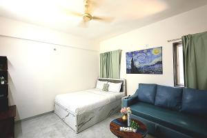 a living room with a bed and a couch at Zenia IT Rooms in Pune