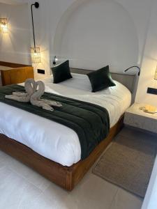 a bedroom with a large bed with two swans on it at Al Jazira Beach & Spa- All Inclusive - Families and Couples Only in Houmt Souk