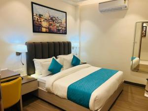a hotel room with a bed with blue pillows at Hotel Vedic Roots in Varanasi