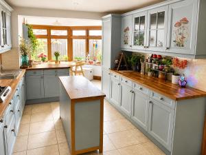 a kitchen with white cabinets and a counter top at Greytree Cottage in Ross on Wye
