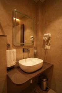 a bathroom with a white sink and a mirror at Hotel Vedic Roots in Varanasi +34 photos