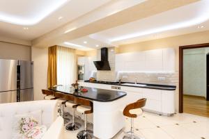 a kitchen with white cabinets and a black counter top at Cityscape Luxury Apartment in Tbilisi City