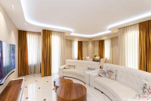 a living room with two white couches and a table at Cityscape Luxury Apartment in Tbilisi City