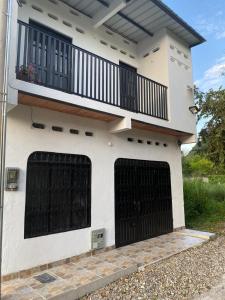 a house with two garage doors and a balcony at Casa Armonia in Honda