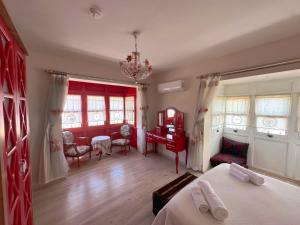 a bedroom with a red bed and a desk and chairs at Evalacati-Villa Palma-Central villa with private pool and garden in Çeşme +59 photos