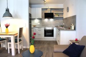 a kitchen and living room with a couch and a table at Bernstein Suite & Breakfast Apartment 05 in Büsum