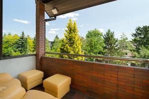 a balcony with stools and a view of trees at Spa & Grill Family Villa - No Parties Allowed in Warsaw
