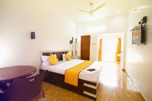 a bedroom with a bed and a table in it at Bluebell Holiday Inn in Yercaud