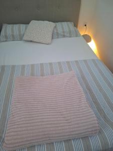 a bed with a pink blanket on top of it at Apartman Atlas in Doboj