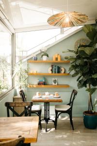 a dining room with a table and chairs and a plant at Hôtel Le Petit Castel in Antibes