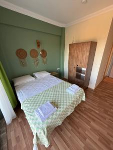a bedroom with a bed with a green wall at Mavi Kuş in Bektaş +4 photos