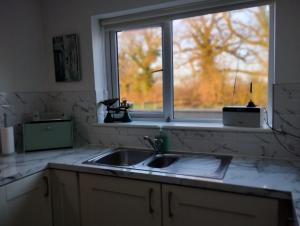 a kitchen counter with a sink and a window at Hillview in Royaloak