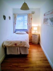 a small bedroom with a bed and a window at Hillview in Royaloak +10 photos