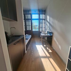 a small kitchen with a sink and a desk at Estelada Studios Unterhaching in Unterhaching