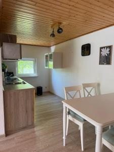 a kitchen and dining room with a table and chairs at Gemütlicher Bungalow in Canow mit Terrasse, Hof und Seenähe in Wustrow +8 photos