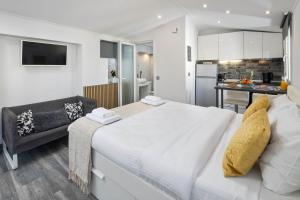 a bedroom with a large white bed and a kitchen at The Loft by Life Homes in Corfu