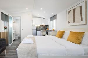 a large white bed in a room with a kitchen at The Loft by Life Homes in Corfu