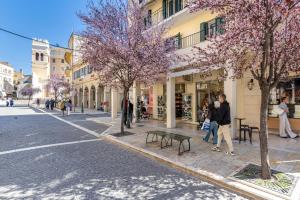 a street with people walking down a street with trees at The Loft by Life Homes in Corfu