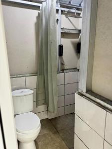a bathroom with a toilet and a shower curtain at Pakis Camping Cikole in Tangkubanperahu